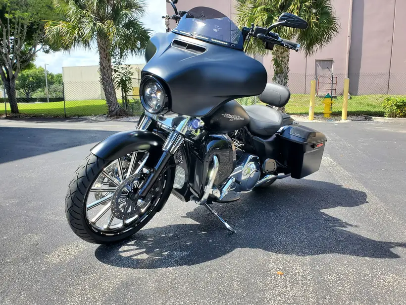 Matte black Harley Street Glide style bagger with a custom front wheel