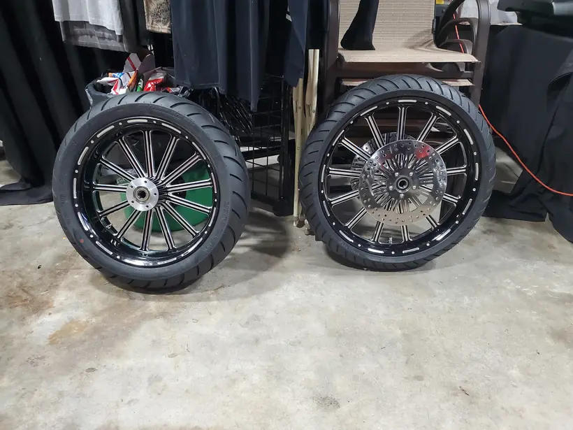 Pair of black custom wheels with new tires on the shop floor