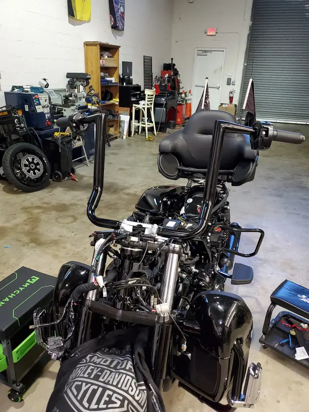 Black ape hangers being fitted to a stripped Harley Ultra Limited