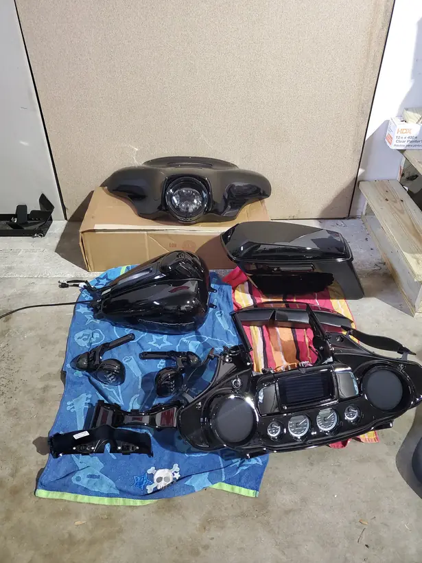 Harley fairing, tank, saddlebag and inner fairing laid out on towels during a build