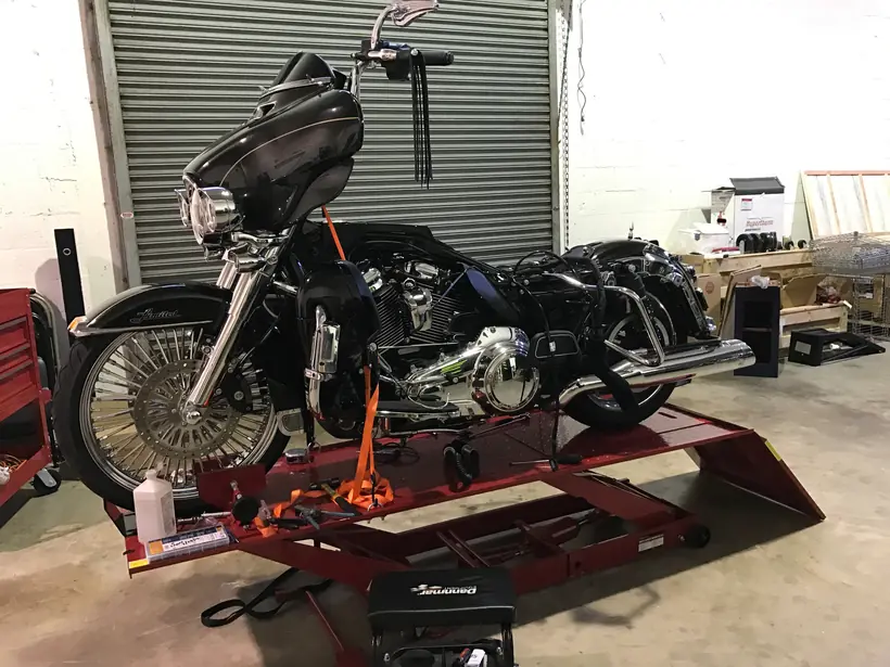 Black Harley Ultra Limited on the shop lift with a spoke front wheel