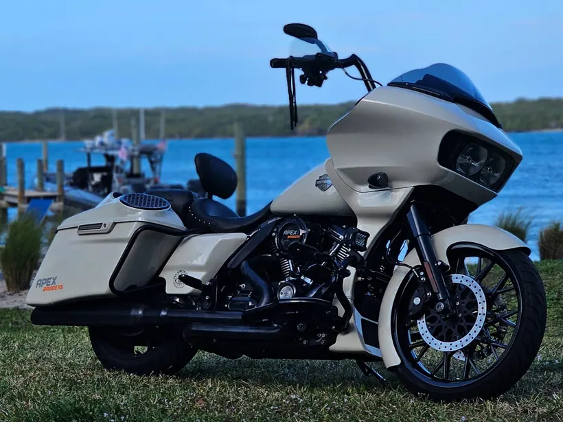 Cream Harley Road Glide with a blacked-out engine parked by the water