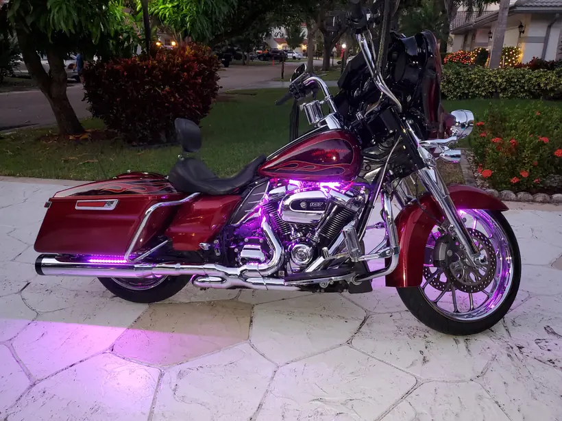 Red Harley Street Glide with purple LED accent lighting at dusk
