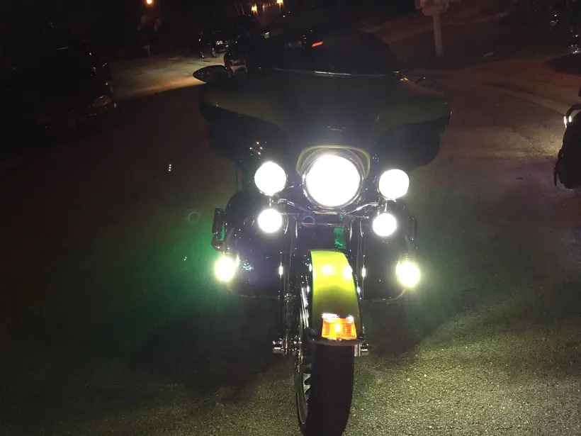 Harley bagger from the front at night with LED headlight and passing lamps on