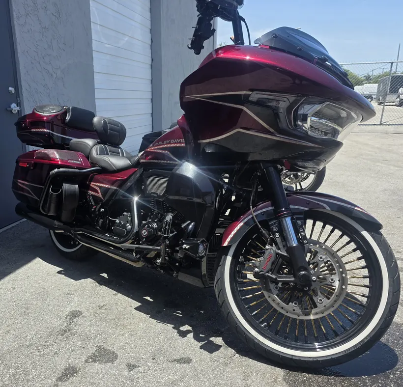 Burgundy Harley Road Glide with a big spoke front wheel and whitewall tire