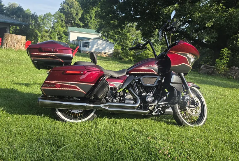 Burgundy Harley CVO Road Glide with gold pinstripes and a Tour-Pak on the grass