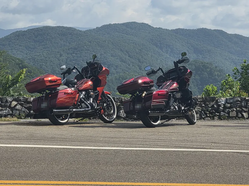 Two red Harley Road Glides with Tour-Paks parked at a mountain overlook
