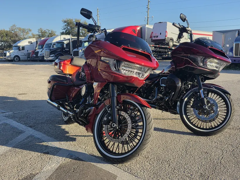 Two red Harley Road Glides parked side by side, front view