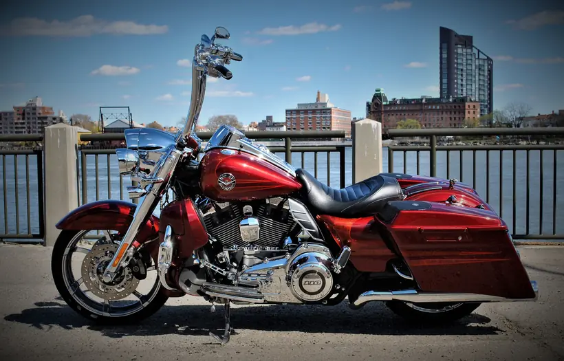 Side profile of a red CVO Road King with stretched bags